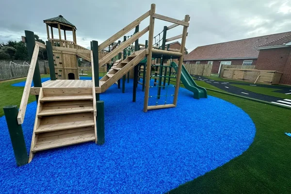 Vibrant blue EPDM Mulch below large multiplay structure in school play area
