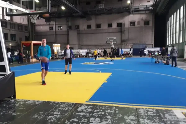Players on blue indoor FlexCourt basketball court with yellow shooting zones