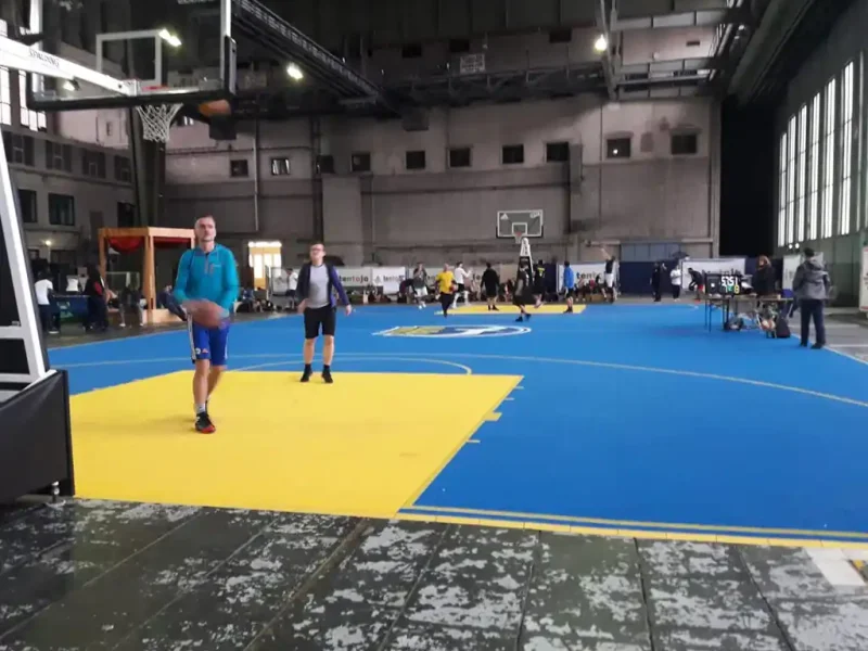 Players on blue indoor FlexCourt basketball court with yellow shooting zones