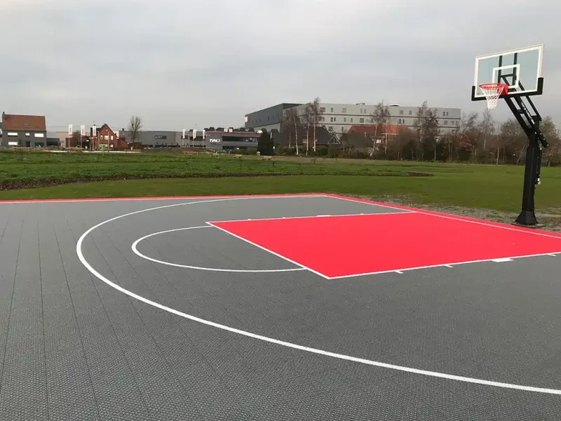 A grey FlexCourt basketball court with red shooting zone