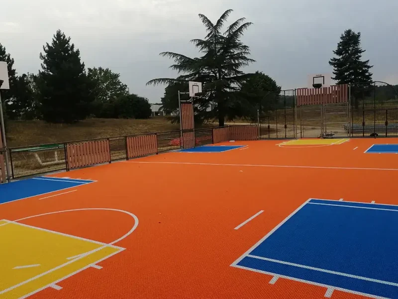 Orange multi use games area MUGA with four basketball hoops and vibrant scoring areas