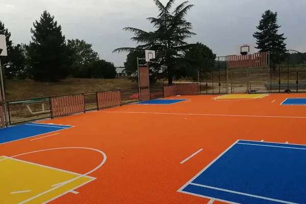 Orange multi use games area MUGA with four basketball hoops and vibrant scoring areas