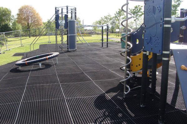 EcoSmart rubber grass mats installed on a playground under various play equipment