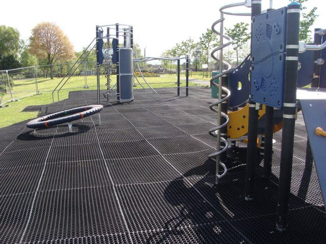 EcoSmart rubber grass mats installed on a playground under various play equipment