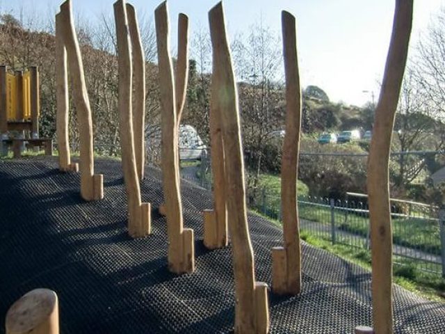 Rubber grass mat surfacing on a hill around obstacle course