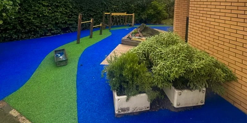 Vibrant green and blue EPDM rubber walkway under playground equipment