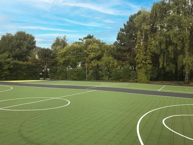 Green rubber sports pitch with a variety of white sports markings