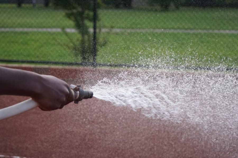 person hosing sports track