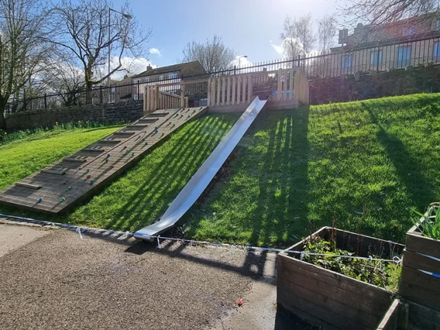 Play slide on hill slope with hybrid artificial grass