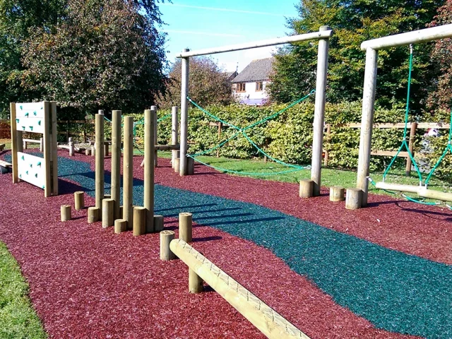 JungleMulch Rubber Mulch Playground with red and dark blue mulch under two trim trails