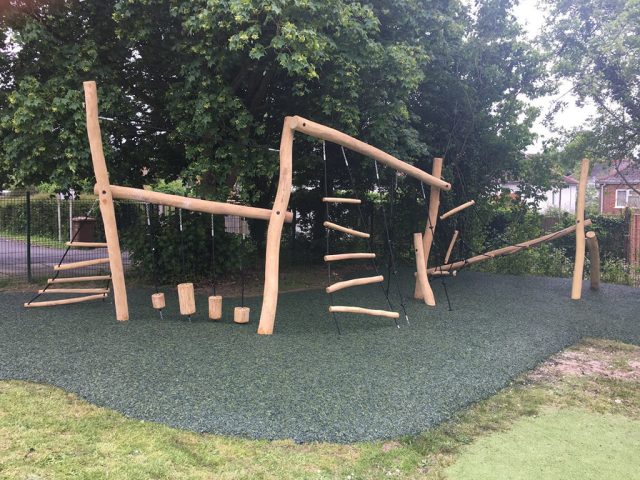 Green Rubber Mulch Playground using JungleMulch underneath natural wooden playground equipment