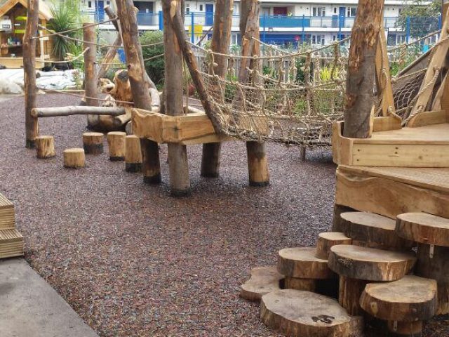 Red Rubber Mulch Playground using JungleMulch underneath natural wooden playground equipment