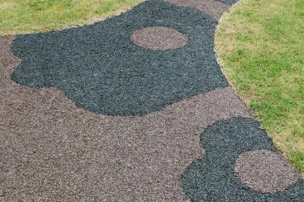 aerial view of black and brown rubber mulch surfacing pattern on grass