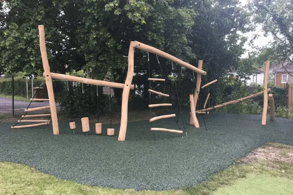 Green Rubber Mulch Playground using JungleMulch underneath natural wooden playground equipment