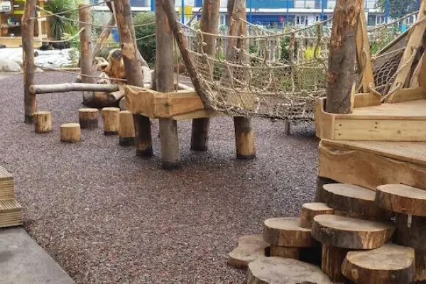 Red Rubber Mulch Playground using JungleMulch underneath natural wooden playground equipment
