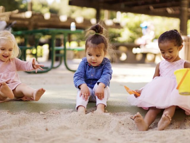 3 girls playing on sand playground flooring