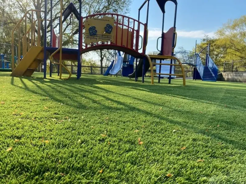 Closeup of LushLawn used at large scale in a play area eith multiplay units