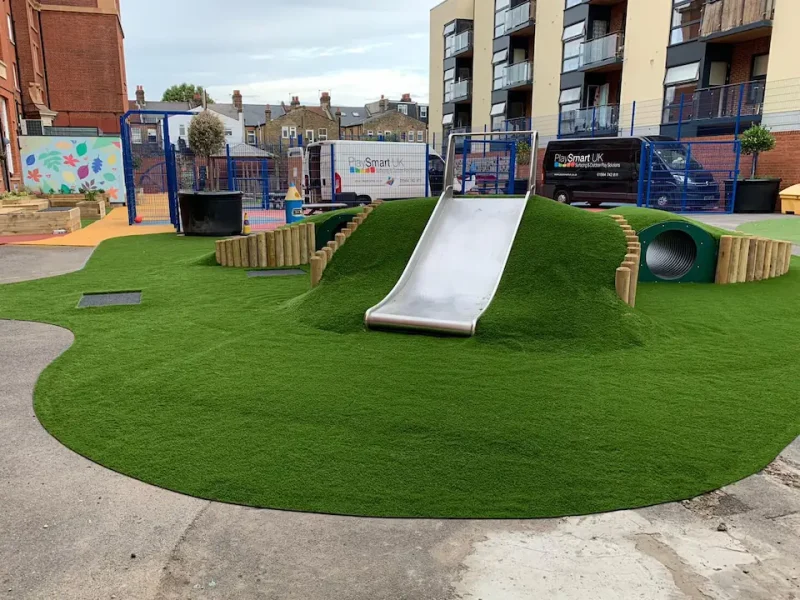 LushLawn covered tunnel and slide outside city school with artificial grass covering all slopes seamlessly