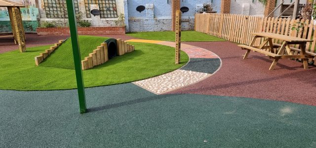 Playground with multiple surfacing materials including EPDM, artificial grass, and more