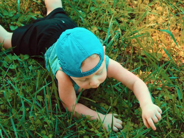 child playing on synthetic grass