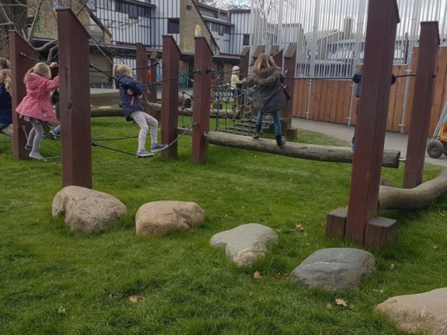 Hybrid grass safety surfacing underneath playground equipment