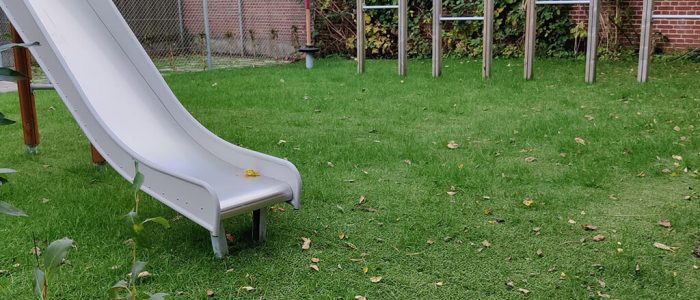 Hybrid grass safety surfacing underneath playground equipment