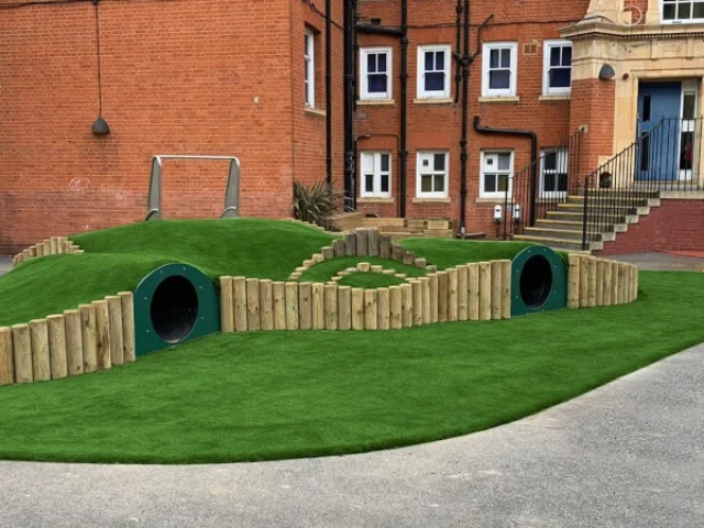 Artificial Grass Mound installation at a school playground with tunnels and slide