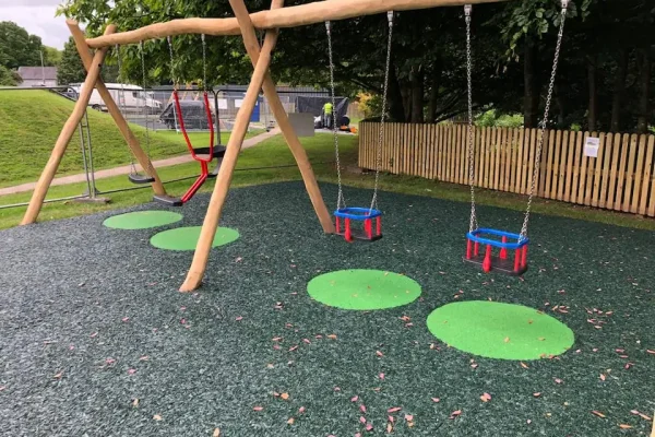 Green Playground with circular EPDM Wear Pads underneath swings