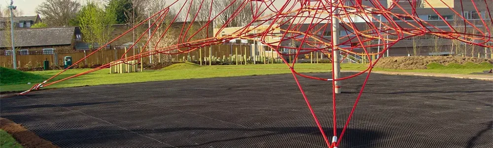 SmartPlay Rubber playground matting installed underneath a large red rope climbing frame
